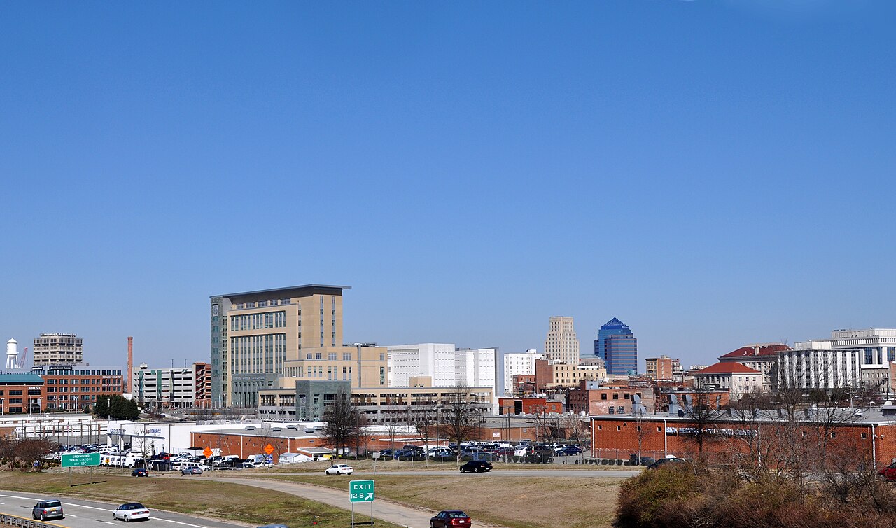 Historic brick buildings and the downtown Durham skyline